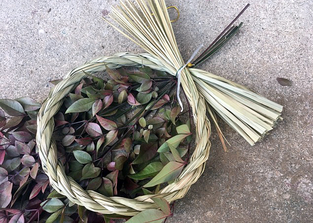 庭の南天と100均のしめ縄を使った正月飾りを作っているところ